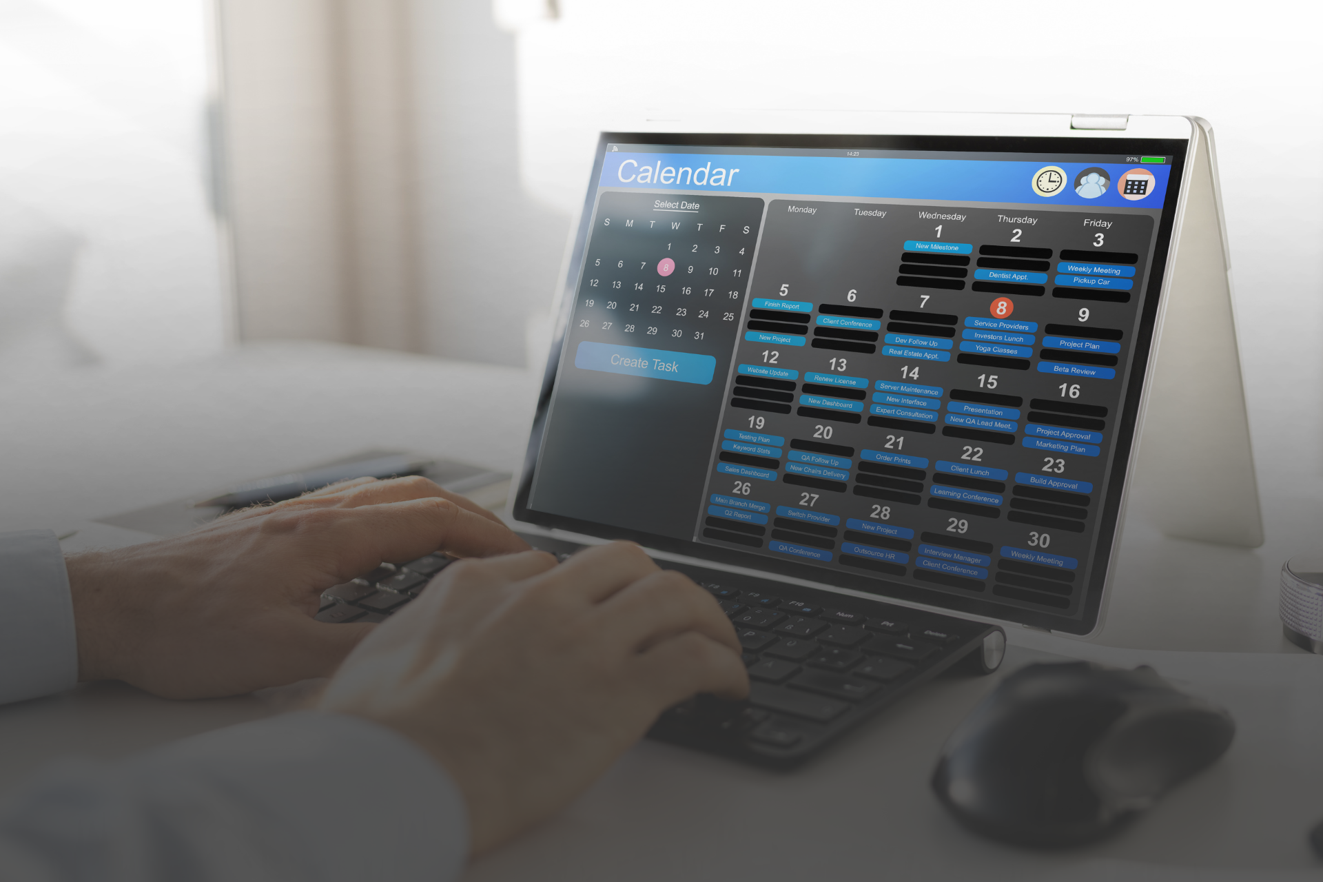 imagem de duas mãos teclando em um notebook com a tela aberta em um calendario 