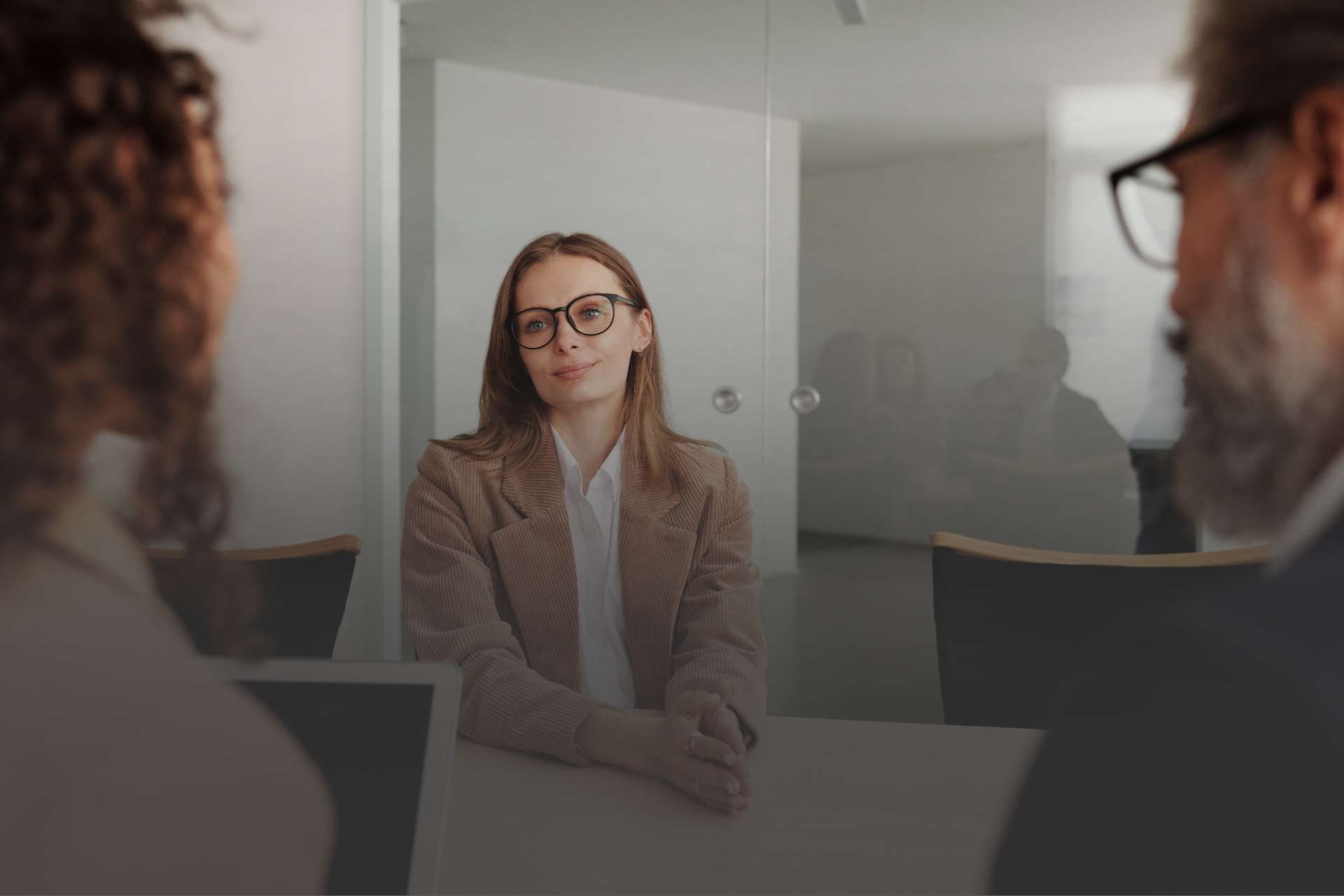 tres pessoas em uma mesa conversando em um ambiente corporativo 